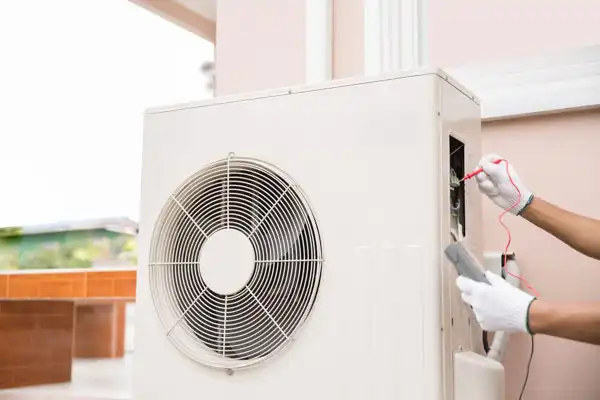 Technician in white gloves repairing an outdoor air conditioning unit using tools.